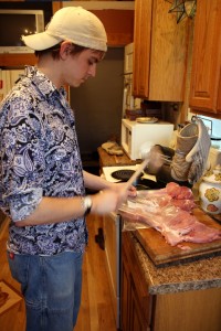 Brandon (Nicholas) flattening the meat for the dish.
